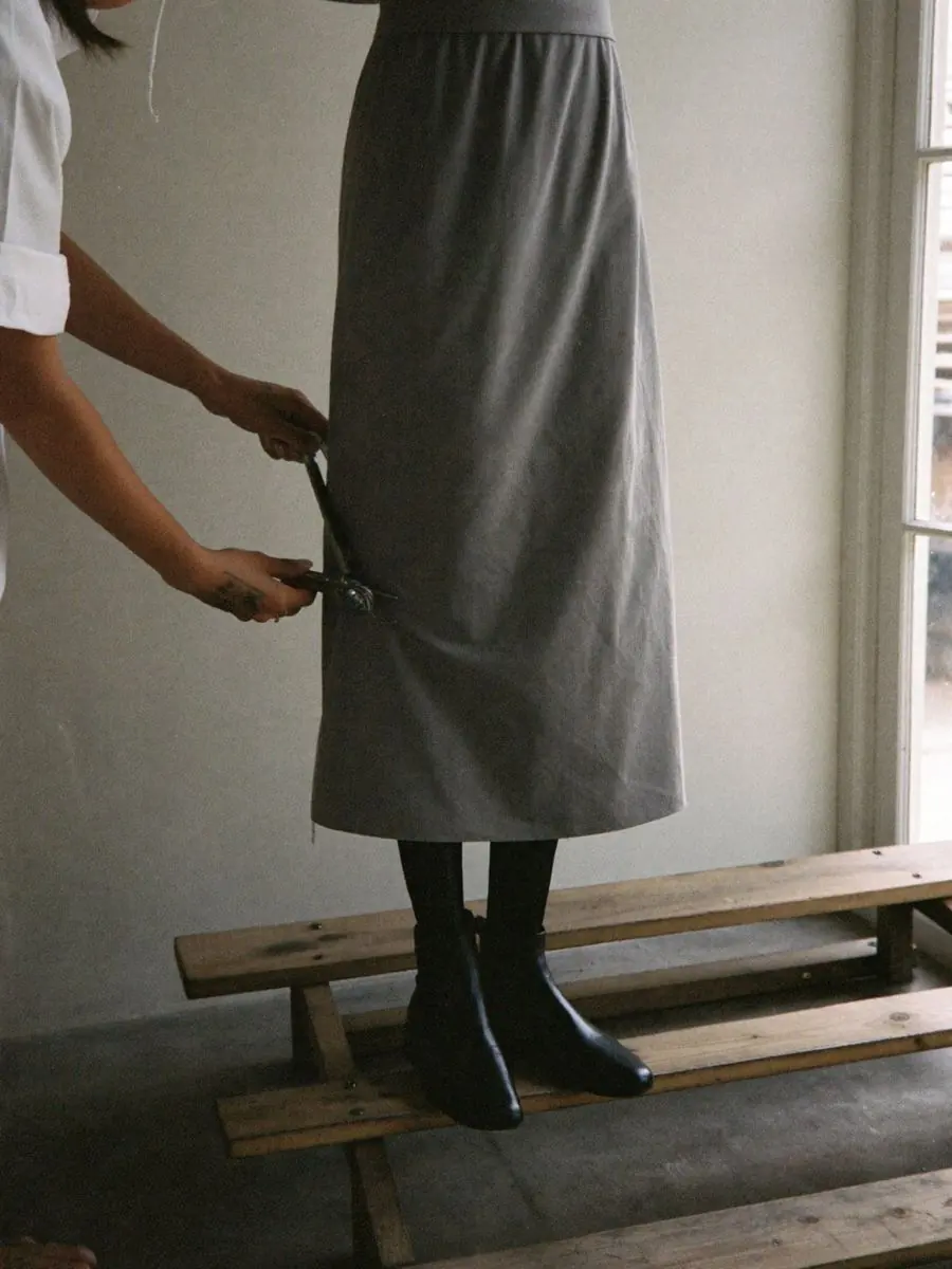 Pinning the hem of a skirt at a fitting